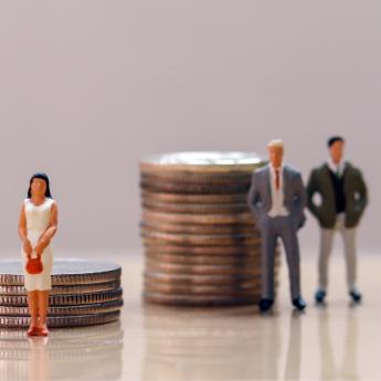 Toy figurines and coins, a wage gap symbol