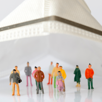 Miniature figures standing under a mask
