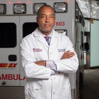 Selwyn Rogers standing in front of an ambulance