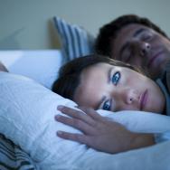 A woman lays awake in bed