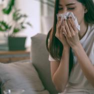 A woman with Covid-19 symptoms uses a tissue